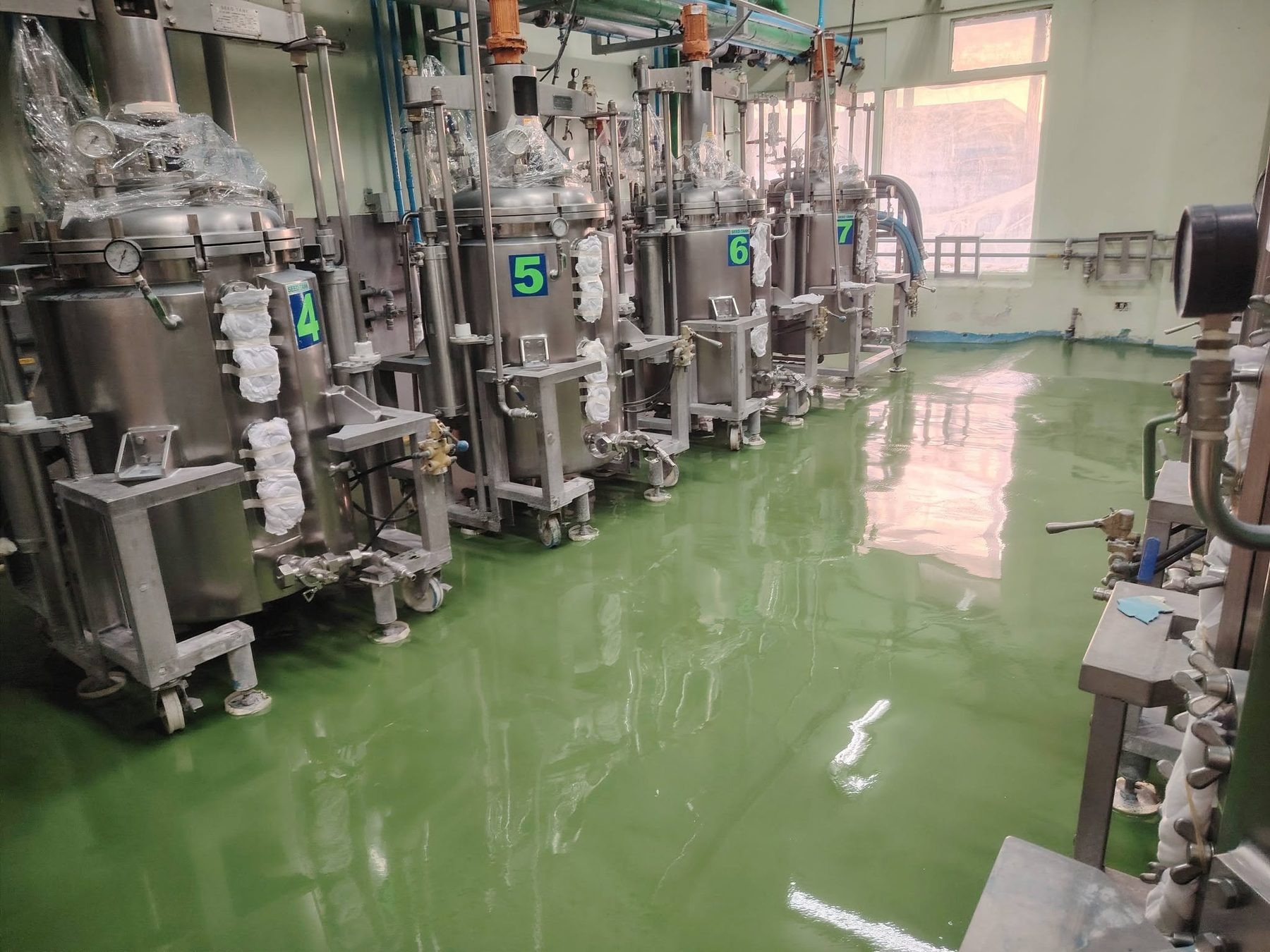 Green epoxy floor in a machine room with stainless equipment