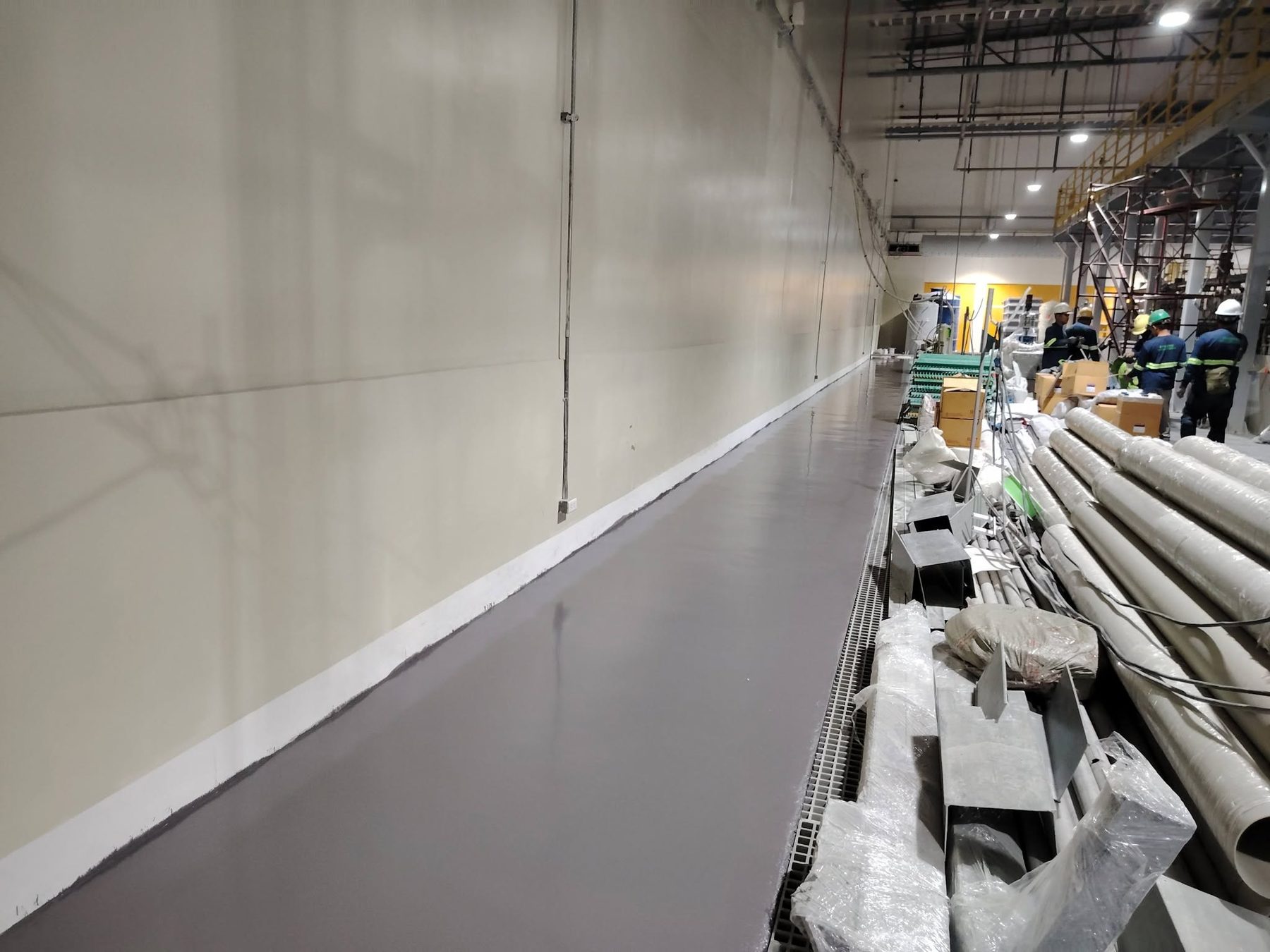 Long gray epoxy walkway beside industrial materials