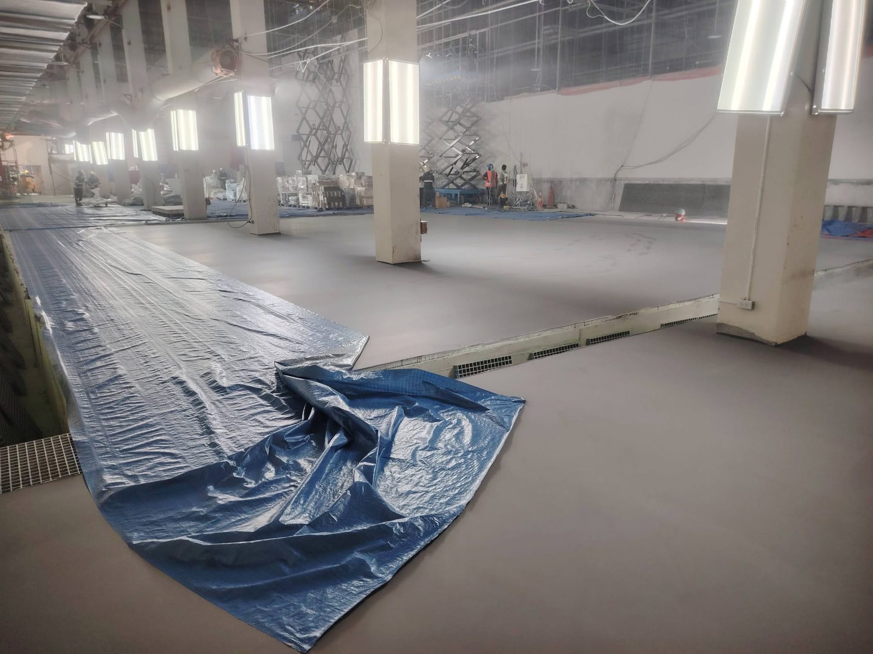 Glossy gray epoxy floor in a large industrial workspace